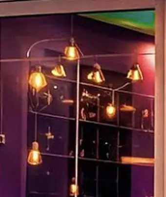 Warm bulbs strung in loops against the violet wall inside the left window.